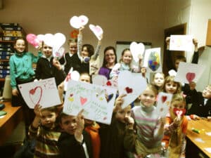 Group of children holding up hand-drawn cards